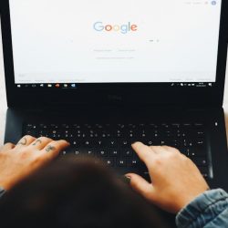 Persoa usando un portátil negro para facer unha busca