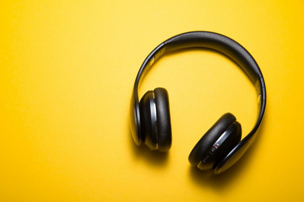Uns auriculares sen fíos sobre unha mesa, listos para escoitar música