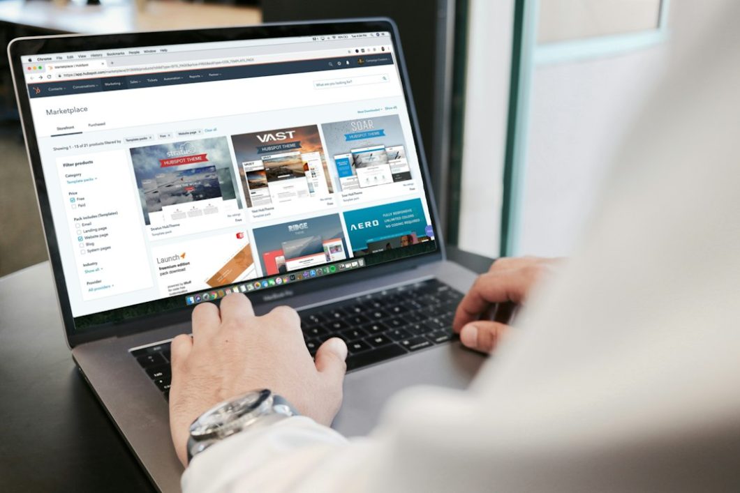 Persoa buscando nun portátil, con resultados de busca na pantalla