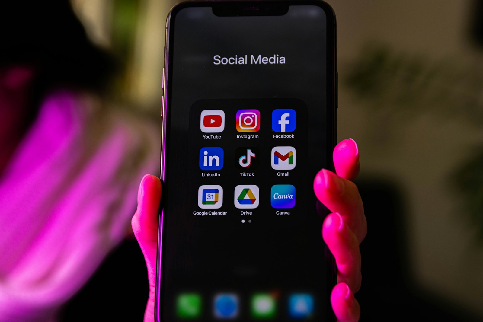 Móbil cunha carpeta de redes sociais con iconas de YouTube, Instagram, LinkedIn e TikTok