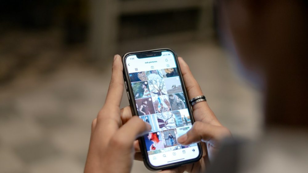 Home usando un móbil para ver vídeos nunha aplicación
