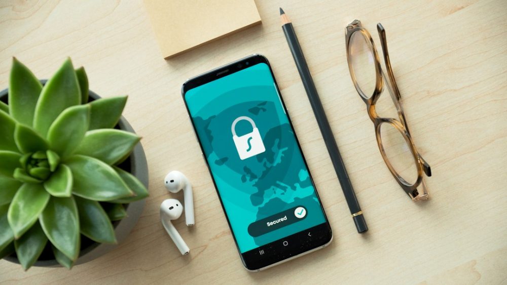 Móbil e candado sobre unha mesa, símbolo de privacidade