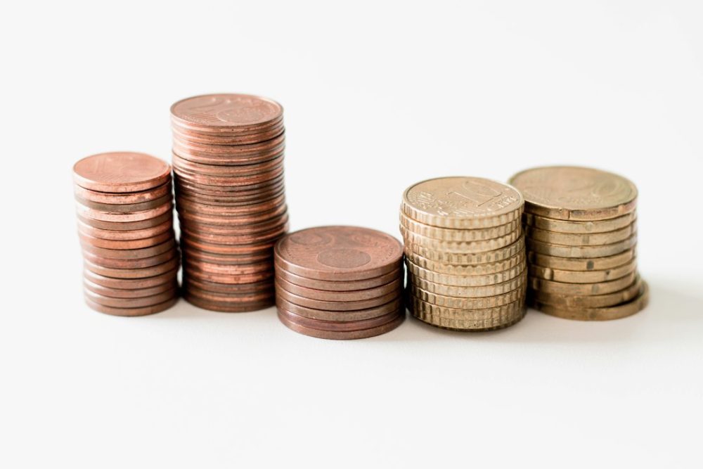 Moedas apiladas diante dun gráfico de crecemento