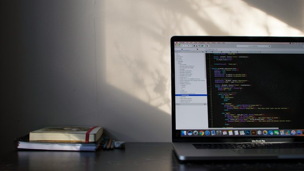 Ordenador portátil con código na pantalla nun escritorio
