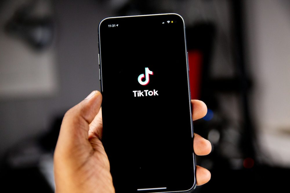 Persoa sostendo un iPhone coa aplicación de TikTok aberta